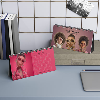 Black Girl Luxe 2026 desktop calendar cover and the month of August featuring a stylish Black women with natural hair, oversized glasses, and luxury fashion on mauve and pink backgrounds.